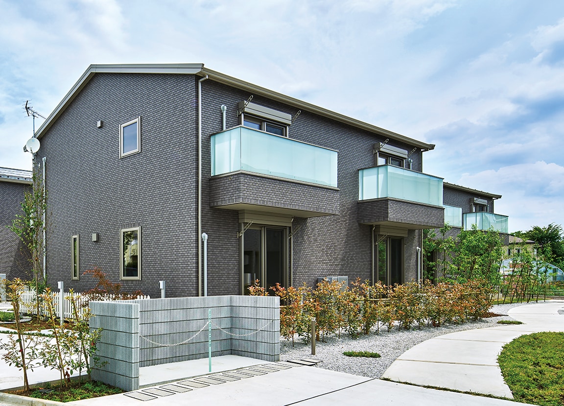 入居者が一戸建て感覚で暮らせる1棟あたり2戸のメゾネット。総二階のシンプルな建物が緑の多い静かな住宅街になじんでいる。