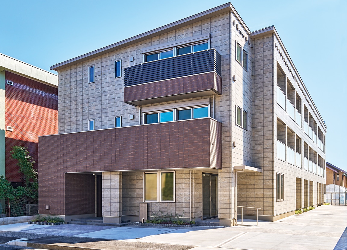 重厚感とモダンが融合する全面タイル張りの外観。正面に茶系タイルを用い、ランドマーク性を高めた。