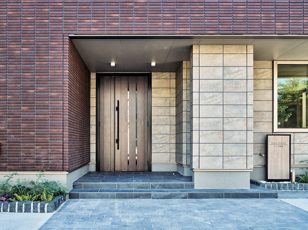 建物に向かって左側に賃貸住宅のエントランスを配置。セキュリティ面を考慮して電気錠を採用。