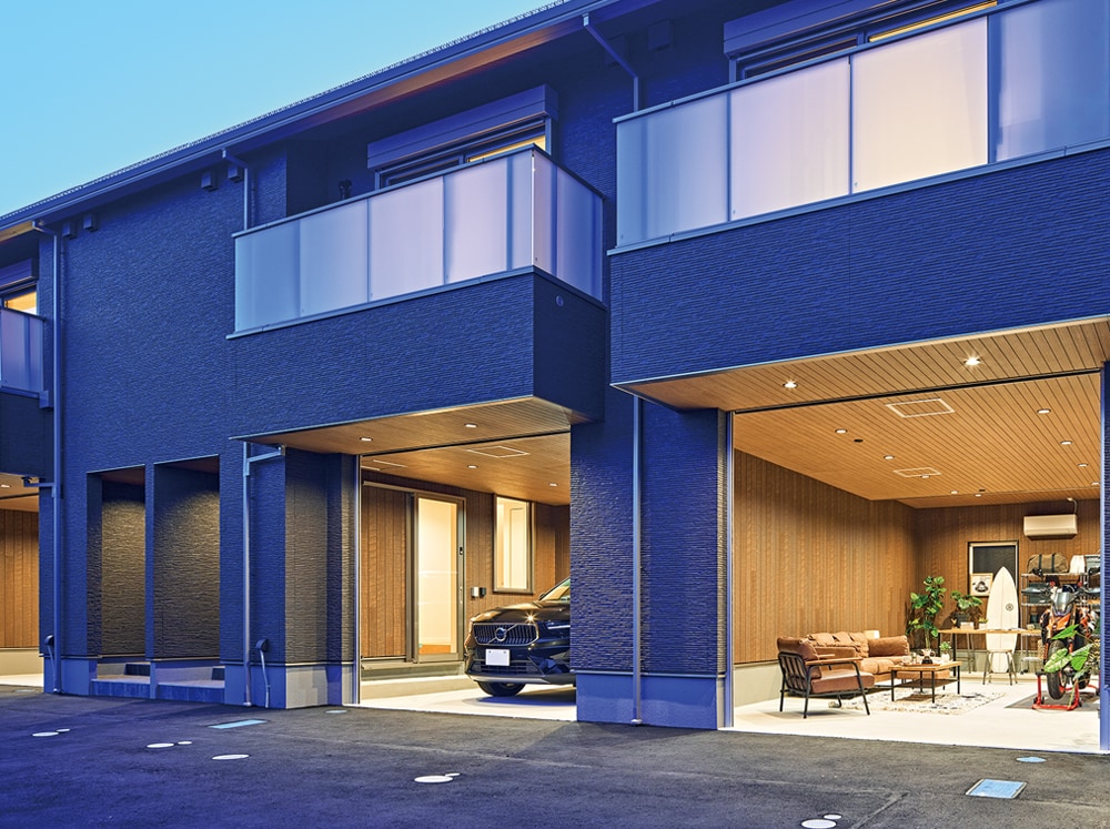 通路からフラットにつながる各戸のガレージ。電動シャッター付きで閉め切ることもできる。洗濯物を干せるようにというEさまのご要望で、2階にはバルコニーを設置。