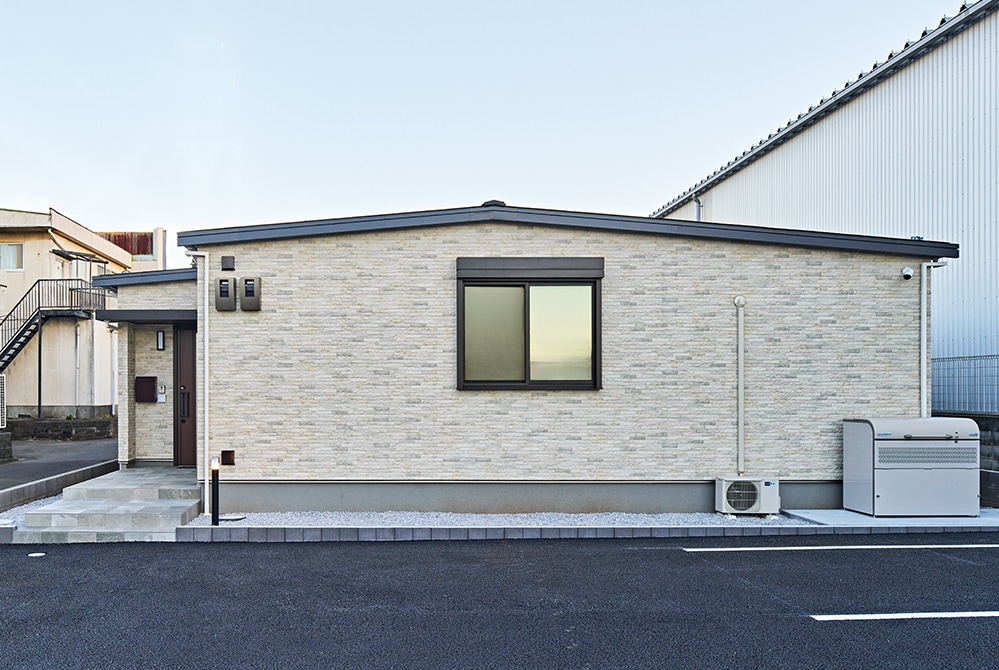 建物を後方から見た様子。スタッフ専用の玄関に隣接して休憩室とミーティングルームが配されている。建物の手前にはスタッフ用の駐車場を完備。