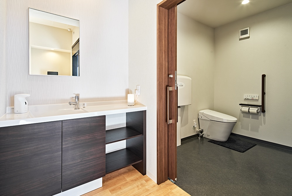 誰もが快適に使えるユニバーサルデザインを取り入れたゆとりある洗面・トイレ空間。トイレの一角にはおむつ交換台も設置した。