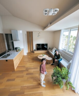 平屋の高天井空間でドローンを飛ばして遊ぶ父と子