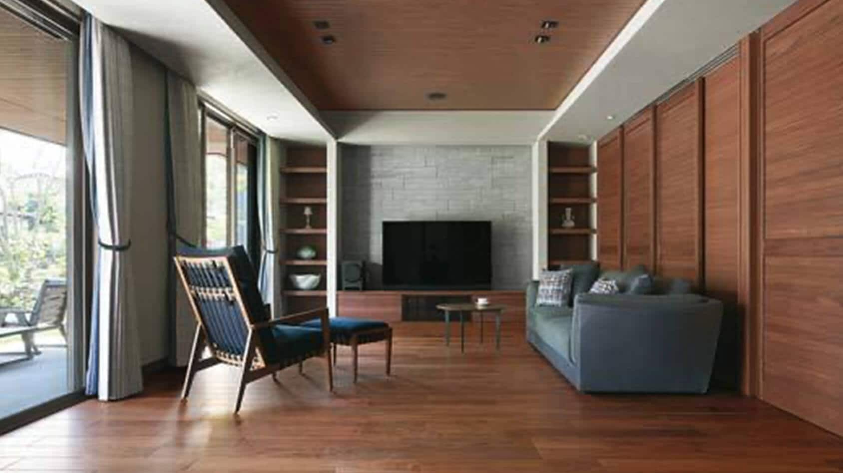 雑木林のような庭園を眺めて、ご夫婦で憩うリゾート感漂う平屋の落ち着きある邸宅の様子